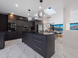 A kitchen with a large island and modern appliances at Alpine Haven - Queenstown Villa in Queenstown
