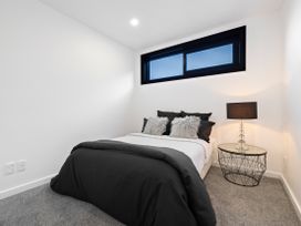 A bedroom with a bed and nightstand at Alpine Haven - Queenstown Villa in Queenstown