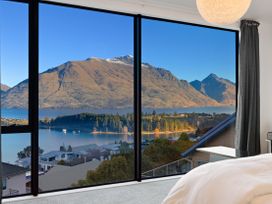 A bedroom with a view of mountains and a lake at Alpine Haven - Queenstown Villa, Queenstown