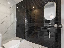 A bathroom with a shower, sink, and toilet at Alpine Haven - Queenstown Villa in Queenstown