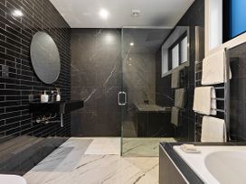 A bathroom with a shower and bathtub at Alpine Haven - Queenstown Villa in Queenstown