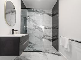 A bathroom with a sink and shower at Alpine Haven - Queenstown Villa in Queenstown