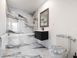 A bathroom with a bathtub, toilet, and sink at Alpine Haven - Queenstown Villa in Queenstown