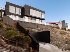 A modern house with a garage and pathway at Alpine Haven - Queenstown Villa in Queenstown