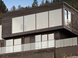 A modern building with large windows and a balcony at Alpine Haven - Queenstown Villa in Queenstown
