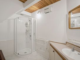 A bathroom with a shower and sink at Alpine Horizon - Queenstown Holiday Home in Queenstown
