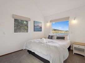 A bedroom with a bed and window at Alpine Horizon - Queenstown Holiday Home Queenstown