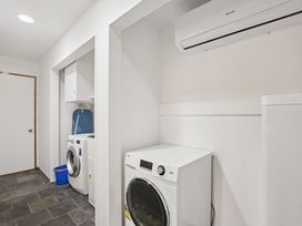 A laundry room with a washing machine and dryer at Alpine Horizon - Queenstown Holiday Home, Queenstown