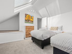 A bedroom with two beds and a dresser at Alpine Horizon - Queenstown Holiday Home, Queenstown