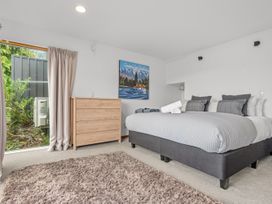 A bedroom with a bed and a dresser at Alpine Horizon - Queenstown Holiday Home in Queenstown