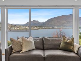 A living room with a sofa and view of the lake at Alpine Horizon - Queenstown Holiday Home Queenstown