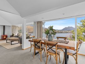 A living room with a wooden table and chairs at Alpine Horizon - Queenstown Holiday Home in Queenstown