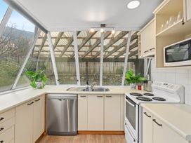 A kitchen with a sink, stove, dishwasher and microwave at Alpine Horizon - Queenstown Holiday Home, Queenstown