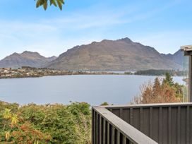 A view of mountains and a lake from a balcony at Alpine Horizon - Queenstown Holiday Home in Queenstown