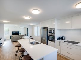 A kitchen with a refrigerator and bar stools at Mayfair Haven - Hastings Holiday Home Hastings