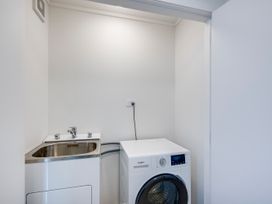 A laundry room with a washing machine and a sink at Mayfair Haven - Hastings Holiday Home, Hastings