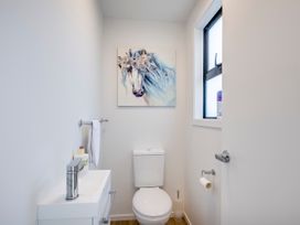 A bathroom with a toilet and artwork on the wall at Mayfair Haven - Hastings Holiday Home, Hastings