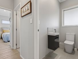 A bathroom with a sink and toilet at Mangawhai Holiday Home in Mangawhai