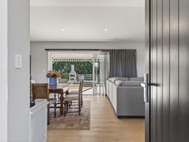 A living room with a table and chairs visible from the entrance at Mangawhai Holiday Home in Mangawhai