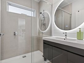 A bathroom with a shower and sink at Mangawhai Holiday Home in Mangawhai