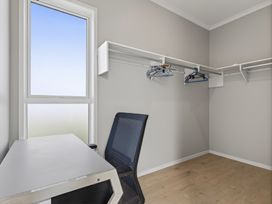 A closet with a desk and hangers at Mangawhai Holiday Home in Mangawhai