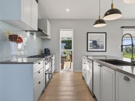 A kitchen with a cooking range and refrigerator at Mangawhai Holiday Home in Mangawhai