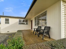 A porch with two chairs at Martinborough Holiday Home in Martinborough