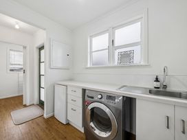 A laundry room with a washing machine and sink at Martinborough Holiday Home in Martinborough