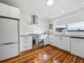 A kitchen with appliances and cabinets at Martinborough Holiday Home in Martinborough