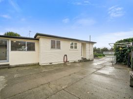 A house exterior with a driveway and backyard at Martinborough Holiday Home in Martinborough