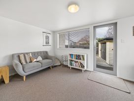 A snug with a sofa and bookshelf at Martinborough Holiday Home in Martinborough