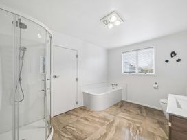 A bathroom with a shower, bathtub, toilet, and sink at Martinborough Holiday Home in Martinborough
