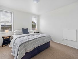 A bedroom with a bed and nightstand at Martinborough Holiday Home in Martinborough