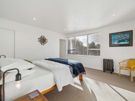 A bedroom with two beds and a chair at Martinborough Holiday Home in Martinborough
