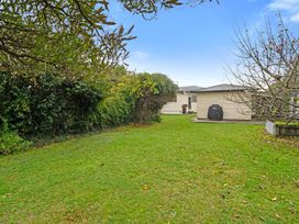 A garden with grass and a house at Martinborough Holiday Home in Martinborough