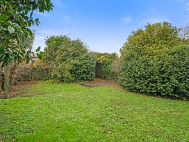 A garden area with grass and hedges at Martinborough Holiday Home in Martinborough