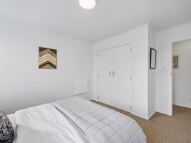 A bedroom with a bed and wardrobe at Martinborough Holiday Home in Martinborough