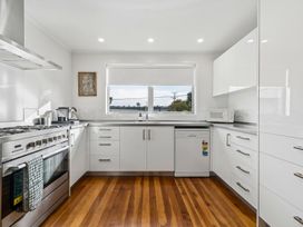 A kitchen with appliances and cabinets at Martinborough Holiday Home in Martinborough