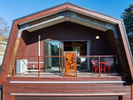 A balcony with table and chairs at Roberts Retreat - Auckland Holiday Home in Laingholm