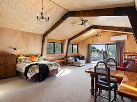 A bedroom with a bed and seating area at Roberts Retreat - Auckland Holiday Home in Laingholm
