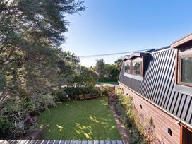 A garden area with grass and trees at Roberts Retreat - Auckland Holiday Home Laingholm