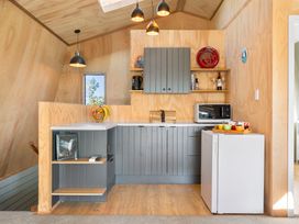 A kitchen area with cabinets and appliances at Roberts Retreat - Auckland Holiday Home in Laingholm
