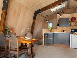 A kitchen with a dining area and cabinets at Roberts Retreat - Auckland Holiday Home Laingholm