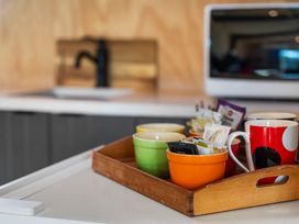 A kitchen with cups and tea bags on a tray at Roberts Retreat - Auckland Holiday Home Laingholm