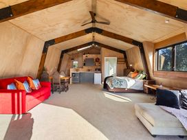 A studio with a sofa and kitchenette at Roberts Retreat - Auckland Holiday Home in Laingholm