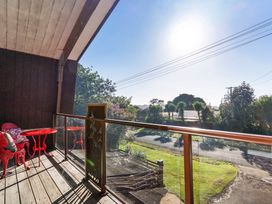 A balcony with a table and chair at Roberts Retreat - Auckland Holiday Home Laingholm