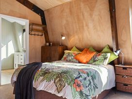 A bedroom featuring a bed with floral bedding at Roberts Retreat - Auckland Holiday Home in Laingholm