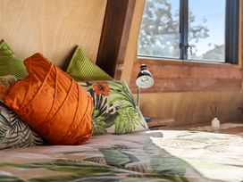 A bedroom with pillows and a bedside lamp at Roberts Retreat - Auckland Holiday Home in Laingholm