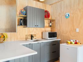 A kitchen with a microwave and refrigerator at Roberts Retreat - Auckland Holiday Home, Laingholm