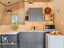 A kitchen with cabinets and appliances at Roberts Retreat - Auckland Holiday Home in Laingholm